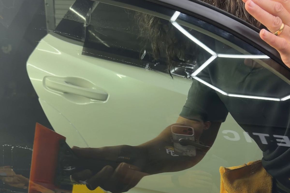 Installing window film on a white car at CEA in Orlando